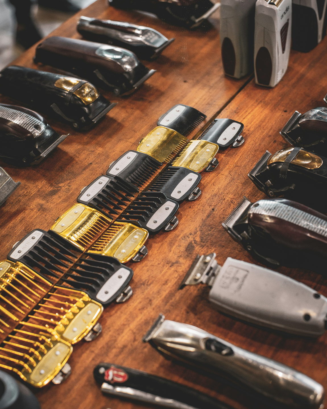 Clippers, guards and shears laid out on the barber's bench