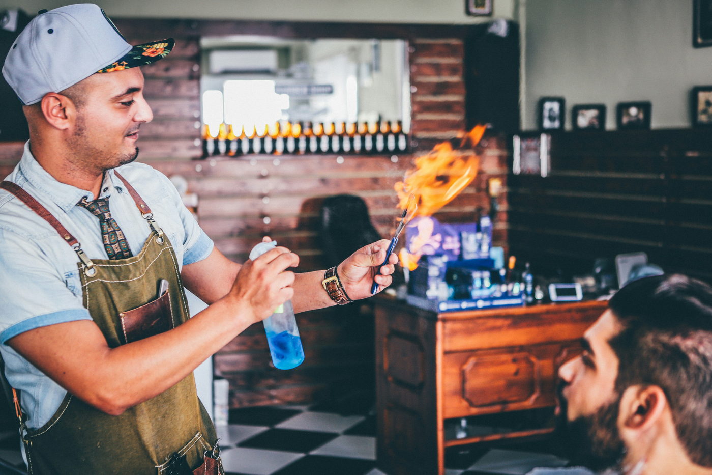Barber finishing a cut with a straight razor singe