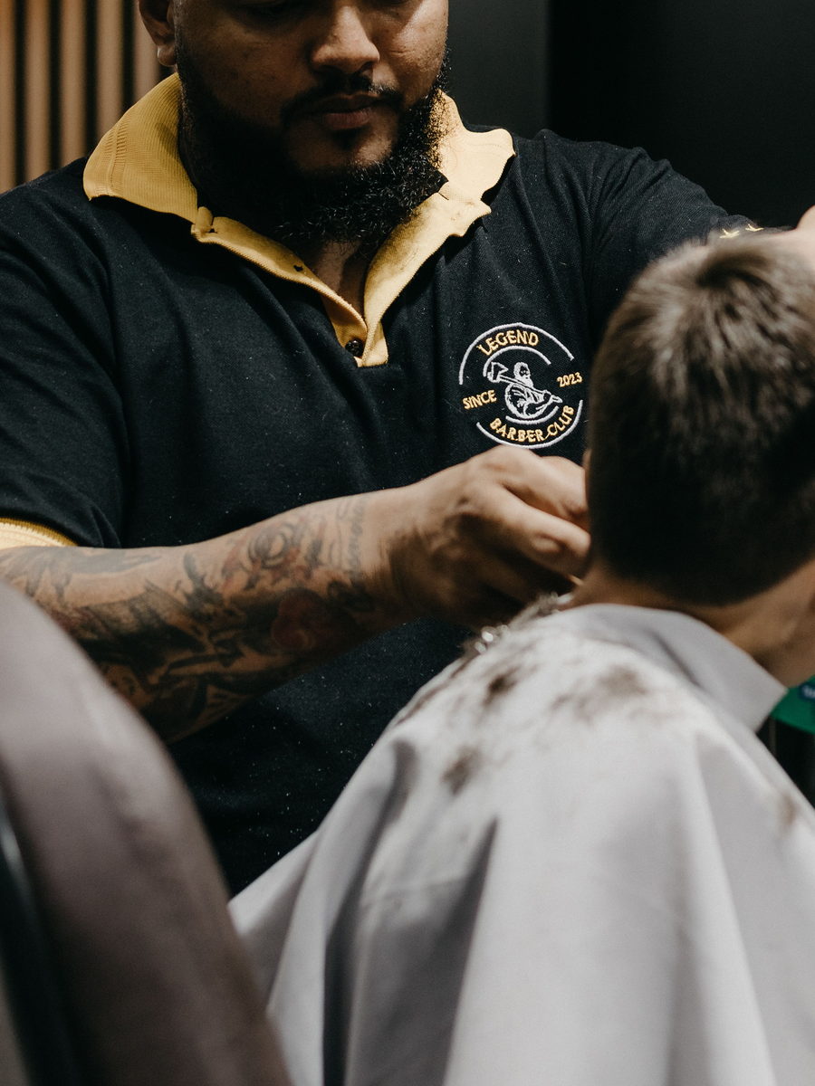 Barber tapering a young client's neckline